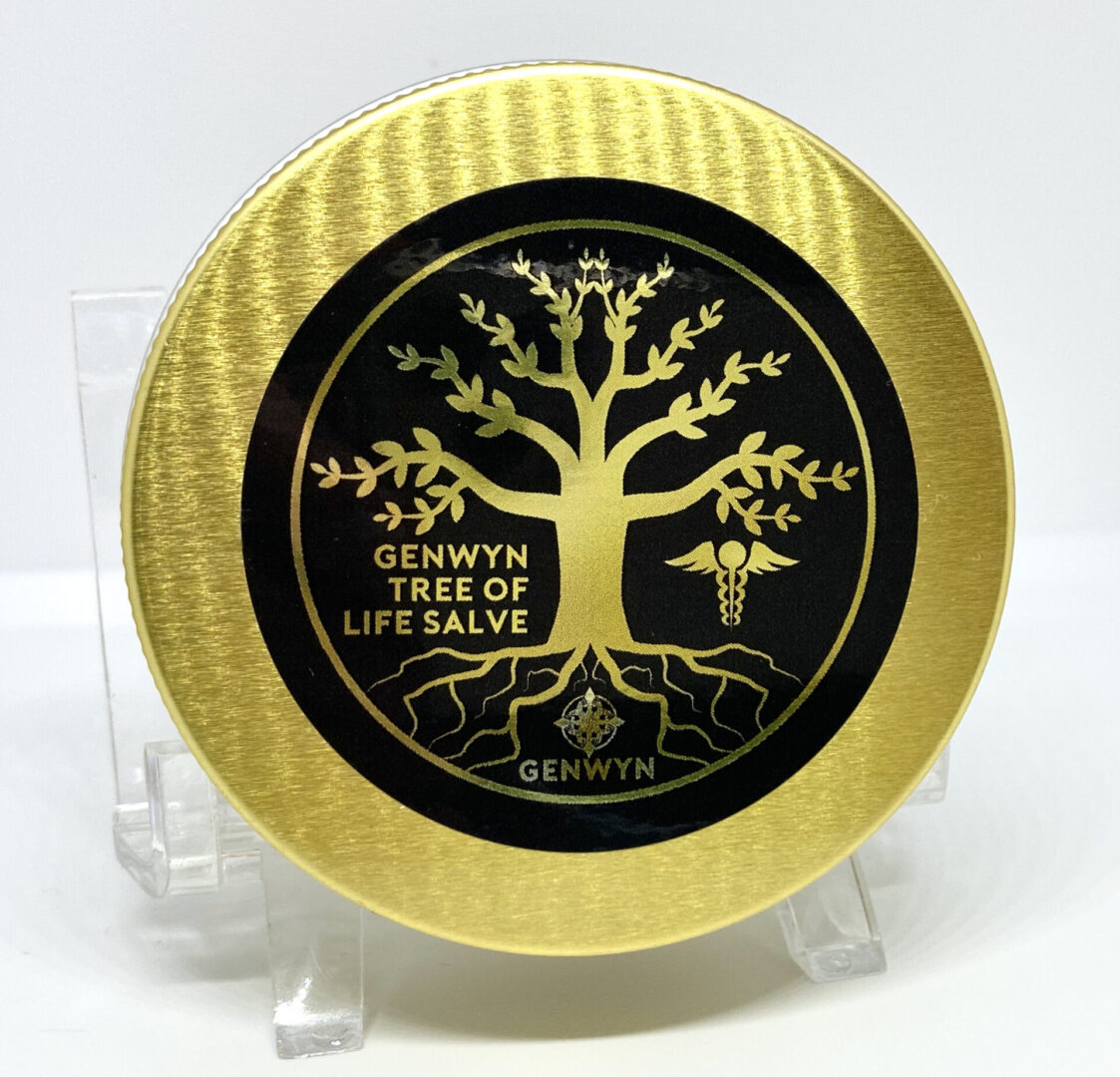 A gold and black plate with a tree of life salve on it.