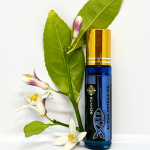 A bottle of aroma oil next to a branch with flowers.