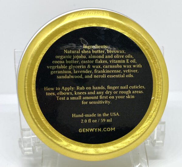 A gold and black container of lotion.