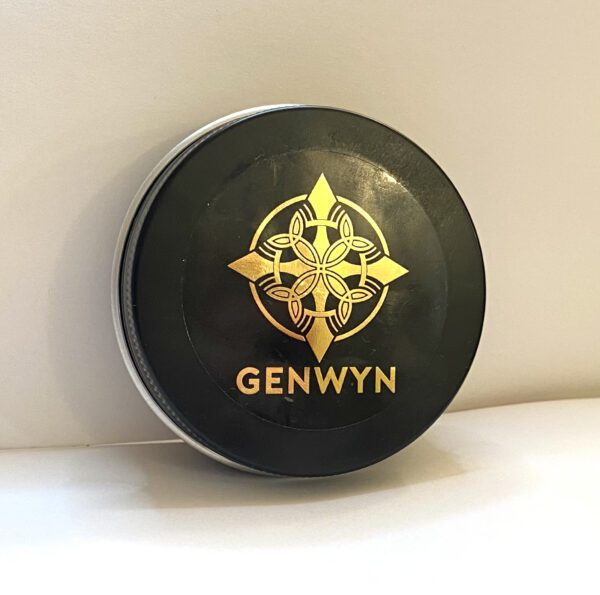 A black and gold logo on top of a round box.